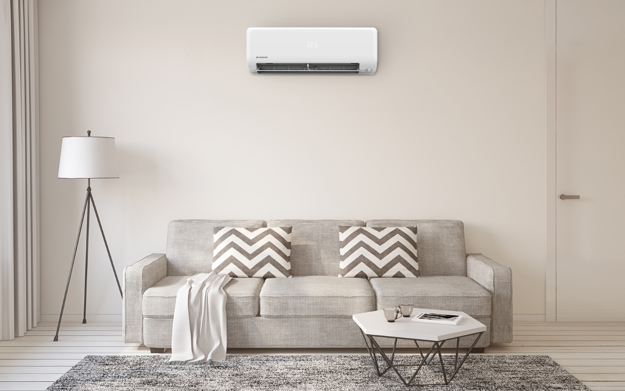 A modern living room with a beige sofa, chevron-patterned cushions, a standard lamp, coffee table, and a wall-mounted air conditioner displaying "23°C" above the sofa—perfect for enjoying comfort enhanced by Mac Trade Services’ battery rebate options.